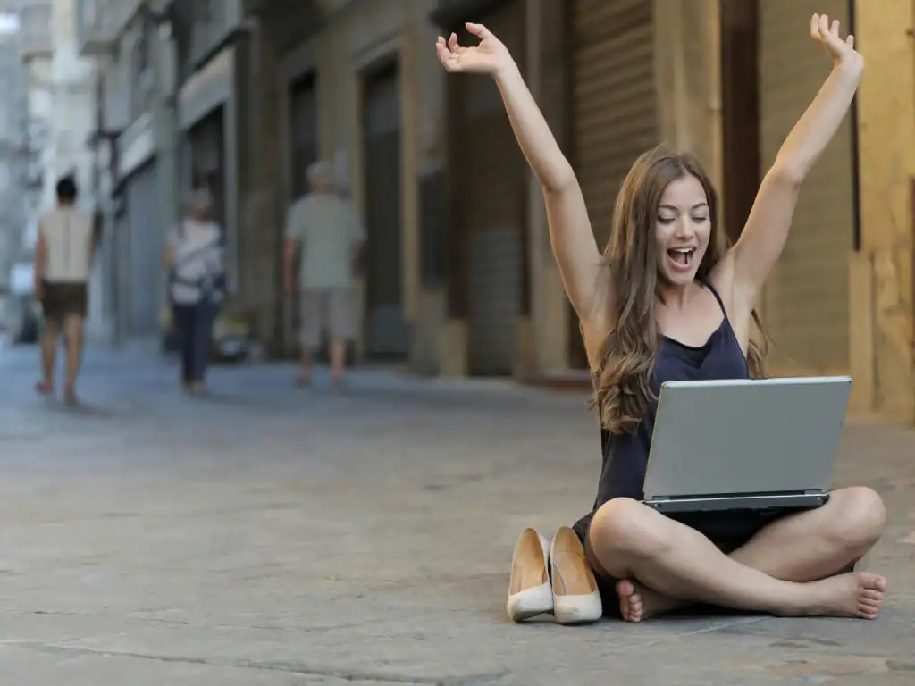 Smiling woman using laptop on street after getting connected in Bolivia