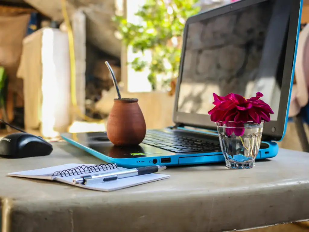 Laptop workspace with traditional South American drink and notebook in Bolivia.