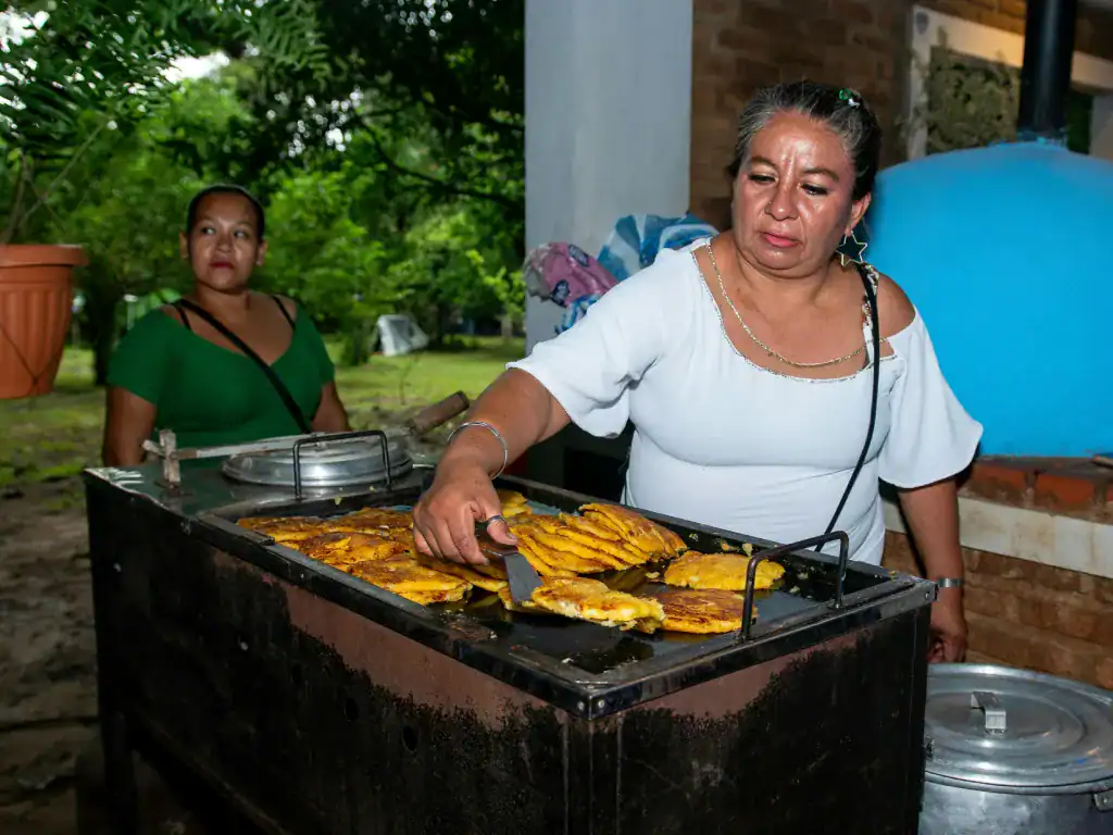 Woman cooking traditional Bolivian snacks outdoors in Santa Cruz de la Sierra, Departamento de Santa Cruz, Bolivia