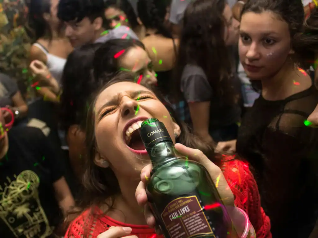 Crowded nightlife party scene with alcohol and dancing inside a busy club in Bolivia.