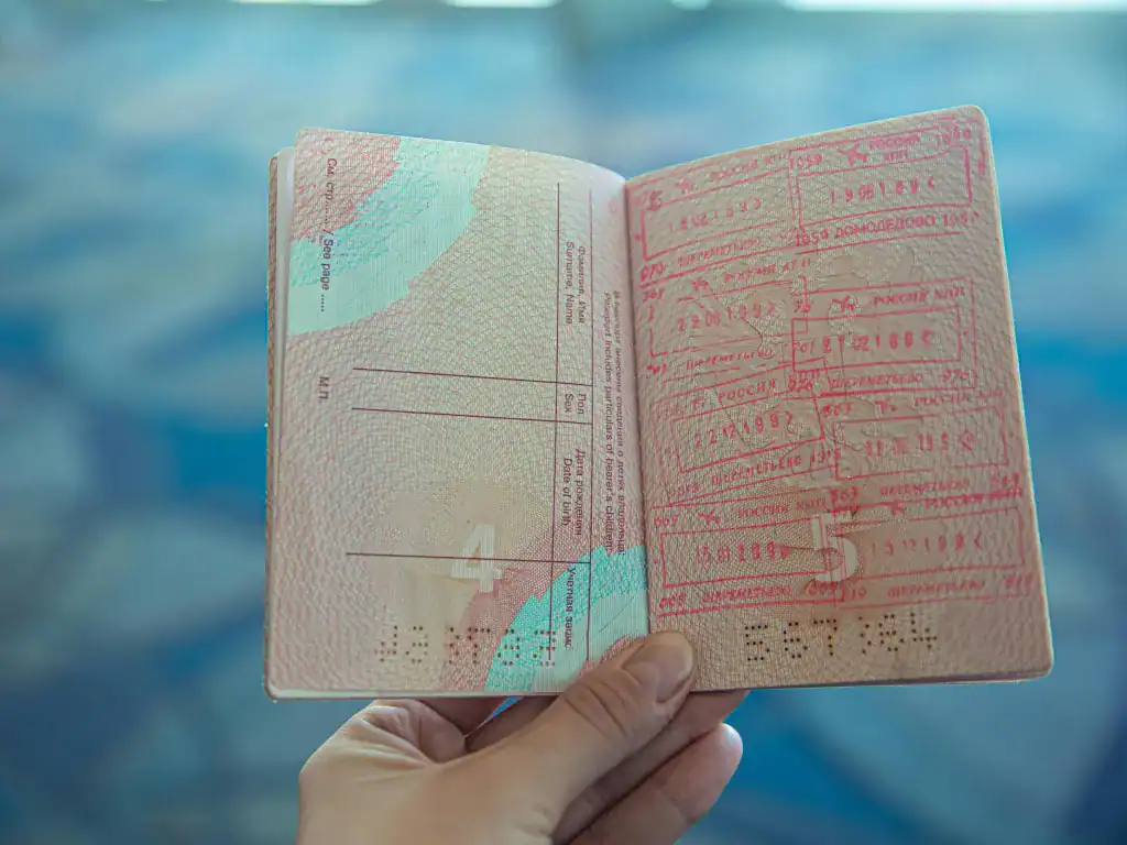 Traveller holding a passport with immigration stamps during an overland border crossing in South America.