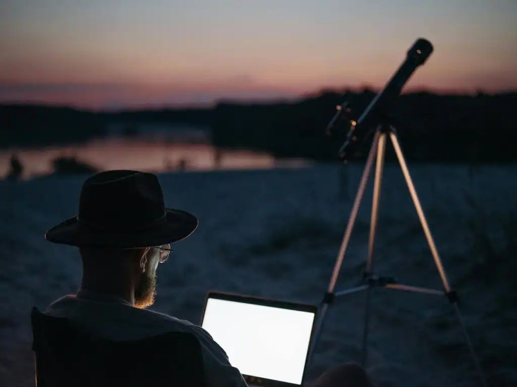 Digital nomad using laptop outdoors at sunset while travelling in Bolivia.
