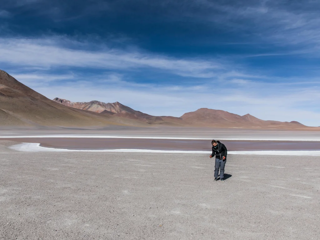 Traveller walking across Bolivia’s remote salt flats during a DIY backpacking trip.