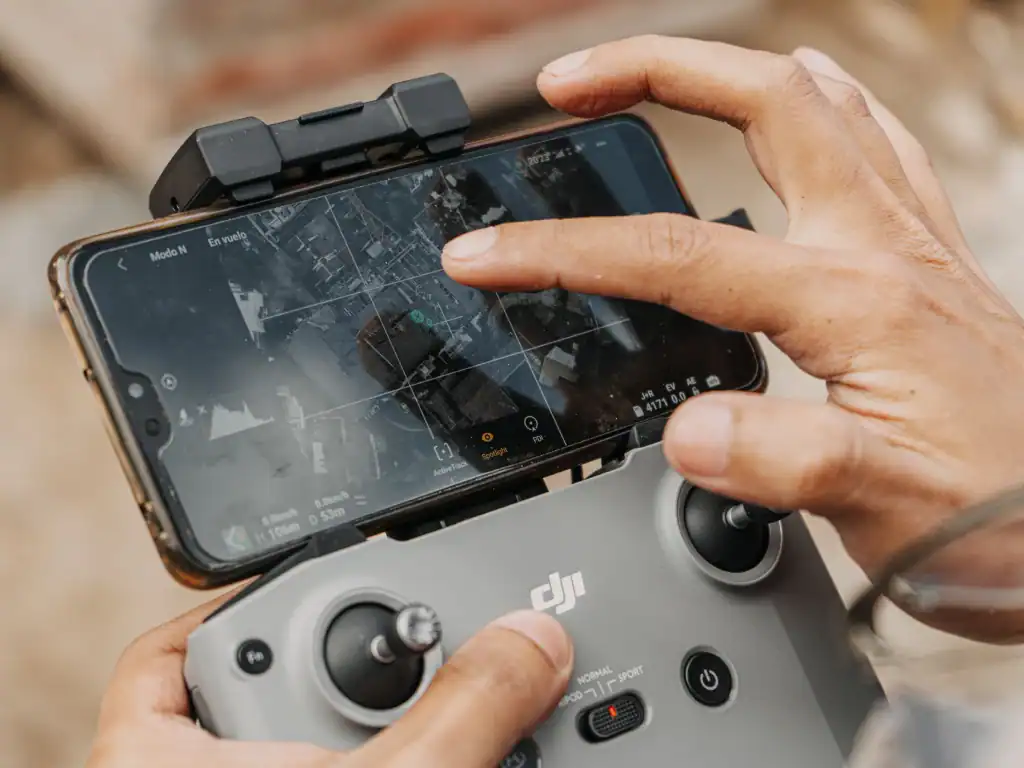 Drone pilot checking flight maps and airspace information on a smartphone before flying in Bolivia