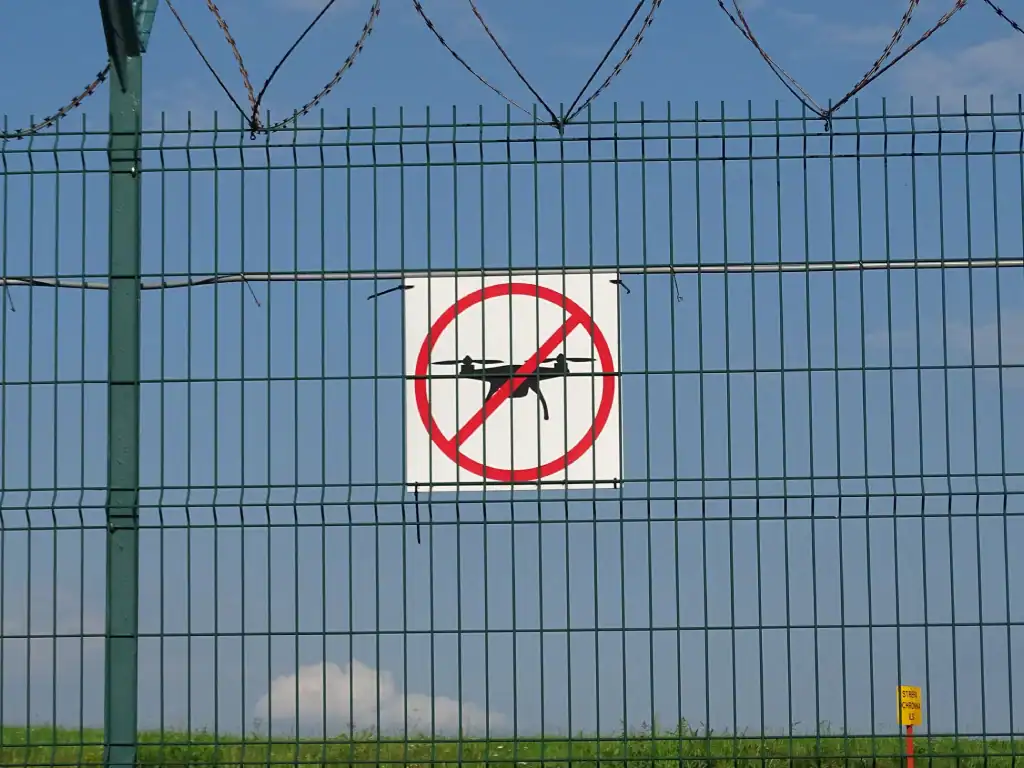 No-drone sign mounted on a security fence highlighting restricted flying areas and drone regulations in Bolivia.
