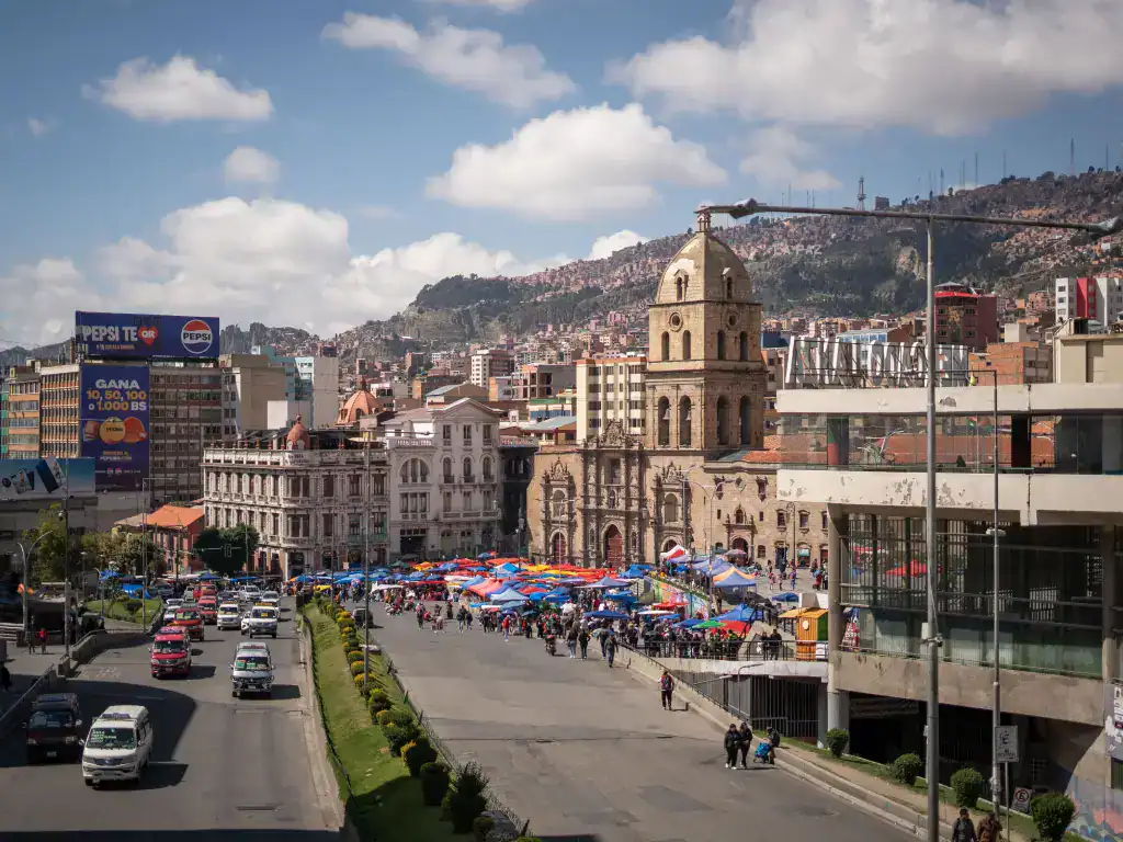 Historic buildings and busy streets in central La Paz with the city's hillside neighbourhoods in the background.
