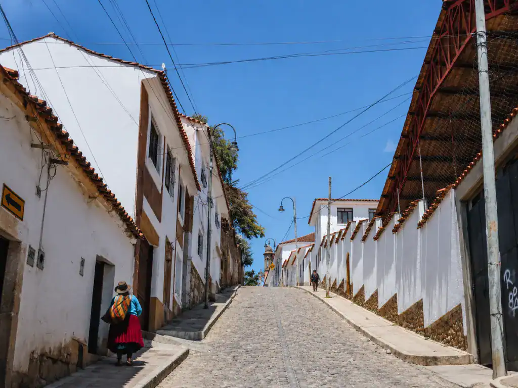 Quiet cobblestone street lined with white colonial buildings in Sucre's UNESCO-listed historic centre.