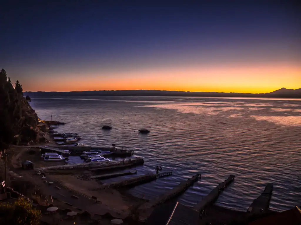 Evening sunset illuminating the tranquil shoreline and harbour on Bolivia's lakeside.