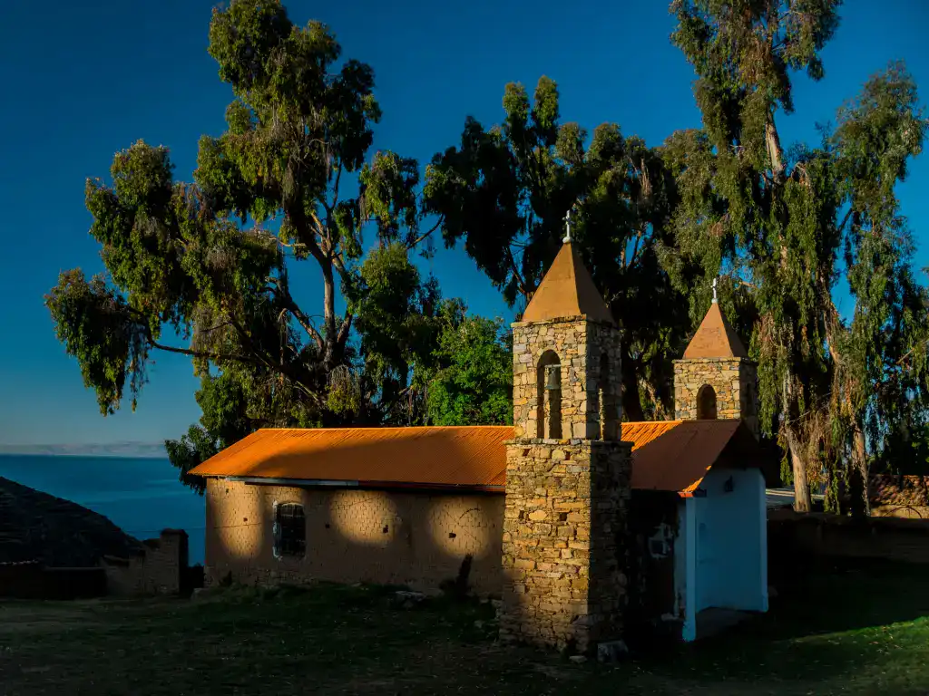 Small historic chapel overlooking the deep blue waters surrounded by eucalyptus trees.
