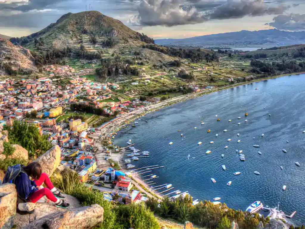 Panoramic overlook capturing the lakeshore, rolling hills and sparkling blue water.