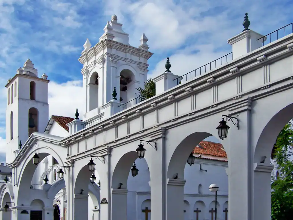 White arches and bell towers of La Merced Church against a blue sky in Sucre, Bolivia.
