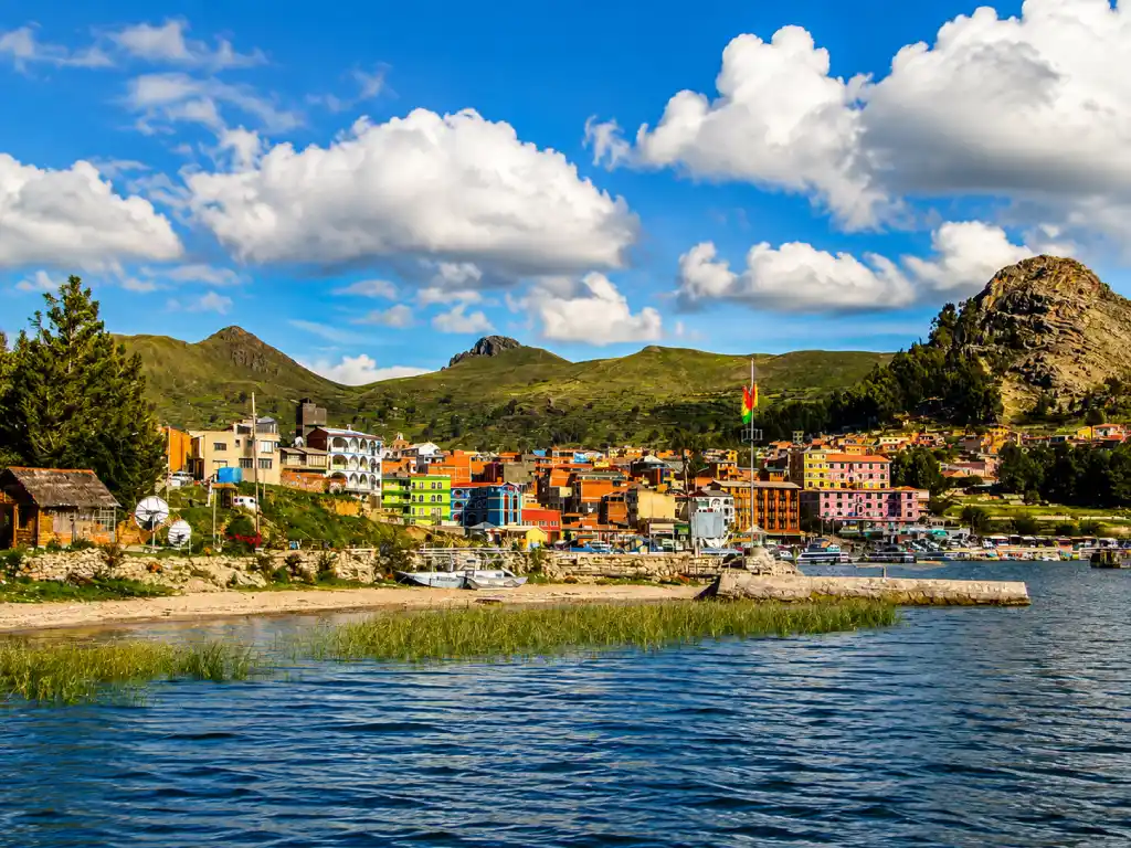 Colourful waterfront of Copacabana Bolivia with surrounding hills and Lake Titicaca.